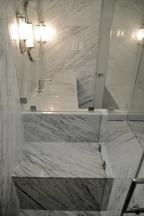 A bathroom shower decorated with light stone